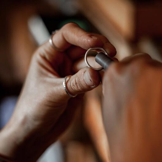 Silversmith sanding and polishing a silver ring